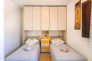 two beds in a small room with cabinets at VILLA Piera SOS ARANZOS -Golfo Aranci Sea View- in Pittulongu
