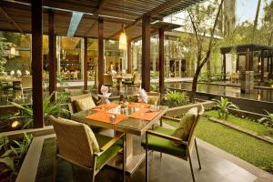a patio with a table and chairs in a restaurant at Hilton Bandung in Bandung