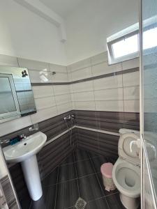 Un baño con lavabo, inodoro y espejo. en Vila Viktori, en Ksamil 41 fotos más