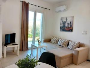 a living room with a couch and a tv at 4T apartments in Argostoli
