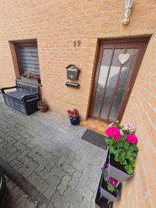 a patio with plants and a door with flowers at Moderne, ruhige Ferienwohnung! in Geistingen