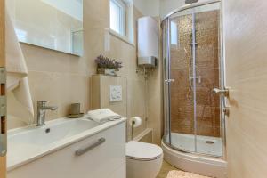a bathroom with a shower and a toilet and a sink at Villa ARIJANA - LAVANDA in Slatine +23 photos