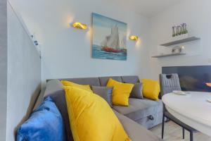a living room with a couch and yellow pillows at Villa ARIJANA - LAVANDA in Slatine