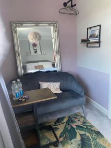 a living room with a blue couch and a mirror at Room in house with breakfast incuded in Llantwit Major