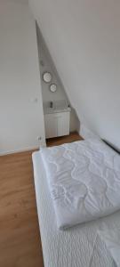 une chambre avec un lit blanc dans une pièce dans l'établissement L'escale marine, à Calais 5 autres photos