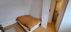 une petite chambre avec un lit avec une couverture marron dans l'établissement L'escale marine, à Calais