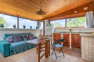 a living room with a blue couch and a kitchen at La Porta Sul Mare - on the sea - Happy Rentals in Diso