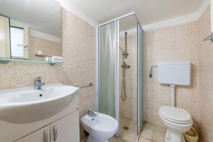 a bathroom with a sink and a toilet and a shower at La Porta Sul Mare - on the sea - Happy Rentals in Diso +17 photos