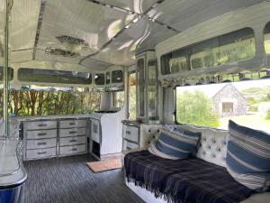 an interior of an rv with a bed and cabinets at The Quarry Caravan in Falmouth +36 photos