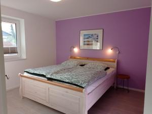 1 dormitorio con 1 cama con paredes moradas en Ferienhaus Ebsen HH links, en Steinberg