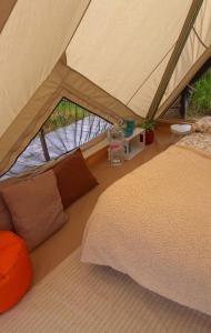 a tent with a bed and pillows in a room at Casa Natura Galicia in Santa María La Mayor del Rosario