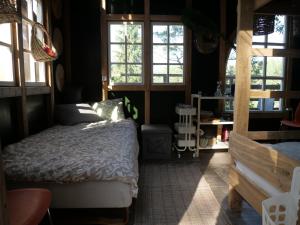 a bedroom with a bed in a room with windows at Vytenio parkas in Sudervė
