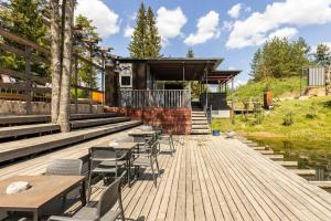 a wooden deck with tables and chairs and a building at Vytenio parkas in Sudervė