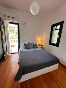 a bedroom with a bed and a large window at Villa Bianca Kavala in Áyios Andréas