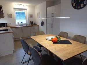 Una cocina y un comedor con mesa y sillas de madera. en Ferienhaus Ebsen HH rechts, en Steinberg