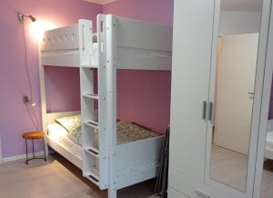 Una litera blanca en una habitación con espejo. en Ferienhaus Ebsen HH rechts, en Steinberg