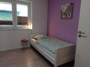 Un dormitorio pequeño con una cama y una pared morada. en Ferienhaus Ebsen HH rechts, en Steinberg 20 fotos más