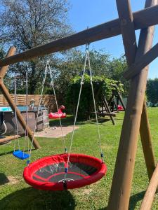 a playground with a red tire swing in a park at Domki pod Polaną in Lesko
