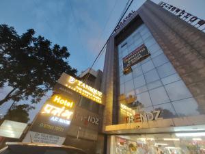 a tall building with signs on the side of it at Hotel PRASANG in Surat