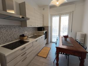 a kitchen with white cabinets and a wooden table at Casa Maria in Opera