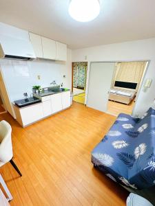 a living room with a couch and a kitchen at メゾンドリバージュ201 in Tokyo