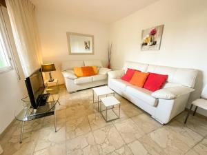 salon z 2 białymi kanapami i telewizorem w obiekcie Apartamentos O Grove 3000 w mieście O Grove