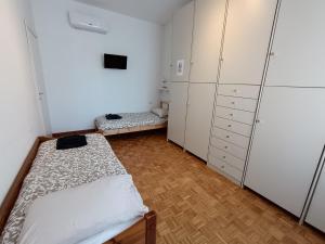 a bedroom with two beds and white cabinets at Casa Maria in Opera