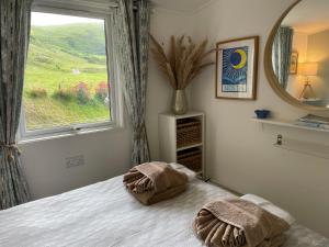 a bedroom with a bed with a large window at Cosy private Chalet in Tywyn