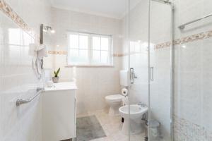 a white bathroom with a toilet and a shower at Moro's Friends House - Cascais in Cascais +41 photos