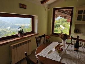 a dining room with a table and two windows at Apartma na podeželju Marta- Slovenia Nature in Kanal +25 photos