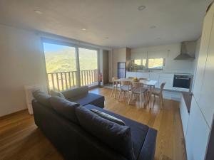 Una sala de estar con un sofá y una mesa con sillas. en Quinta da Valdigueira, en Armamar