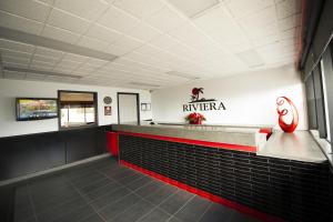 a waiting room with a red counter and a sign on the wall at Riviera Motor Inn in Saskatoon