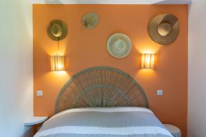 a bedroom with an orange wall with a bed at La Cabane Ô Rêves in Genouilleux