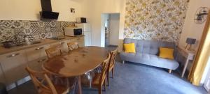 a kitchen and dining room with a table and a couch at Gite clos masure Blévillot in Saint-Gilles-de-la-Neuville