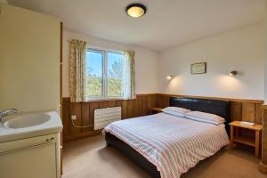 1 dormitorio con cama y lavamanos en Churchwood Valley, en Plymouth