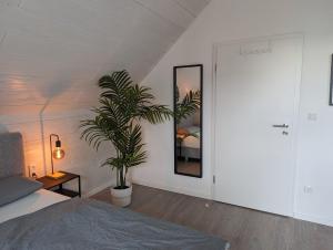 a bedroom with a bed and a potted plant at Feeling in Hamm