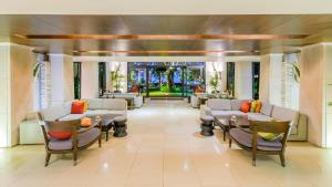 a lobby of a hotel with chairs and tables at Impiana Beach Front Resort Patong, Phuket in Patong Beach