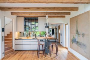 a kitchen with wooden ceilings and a counter with stools at steiRerBLiCke - Winzerhäuser an der südsteirischen Weinstraße in Glanz an der Weinstraße  +61 photos