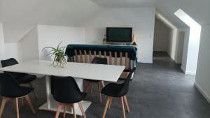 a dining room with a white table and chairs at Appartement 8 pers neuf 80m2 in Solesmes