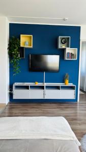a living room with a tv on a blue wall at Classy Villány in Villány +14 photos