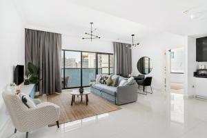 ein weißes Wohnzimmer mit einer Couch und Stühlen in der Unterkunft GuestReady Holiday Homes - Light Abode in Dubai