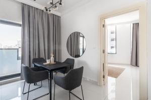 ein Esszimmer mit Tisch und Stühlen und einem Spiegel in der Unterkunft GuestReady Holiday Homes - Light Abode in Dubai