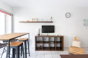a living room with a table and a tv on a wall at GuestReady - Appartement Cours du Médoc in Bordeaux +7 photos