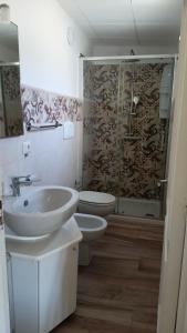 a bathroom with a sink and a toilet and a shower at Casa vacanze da Cosimo BEIGE in Porto Cesareo
