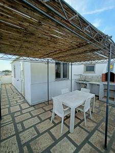 a white table and chairs on a patio at Casa vacanze da Cosimo BEIGE in Porto Cesareo