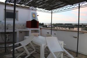 a white table and chairs on a balcony at Casa vacanze da Cosimo BEIGE in Porto Cesareo +3 photos