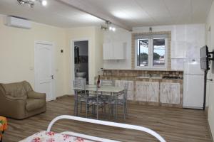 a kitchen and living room with a table and a couch at Casa vacanze da Cosimo BEIGE in Porto Cesareo