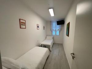 une petite chambre avec deux lits et une fenêtre dans l'établissement Saint Michel 3 piano, à Gorizia