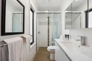 a white bathroom with a toilet and a sink at TwentyTwo on Twynam in Jindabyne +19 photos