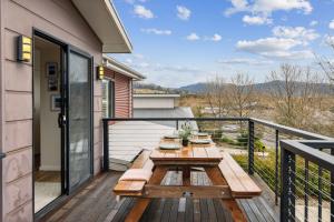 a wooden table on the balcony of a house at TwentyTwo on Twynam in Jindabyne